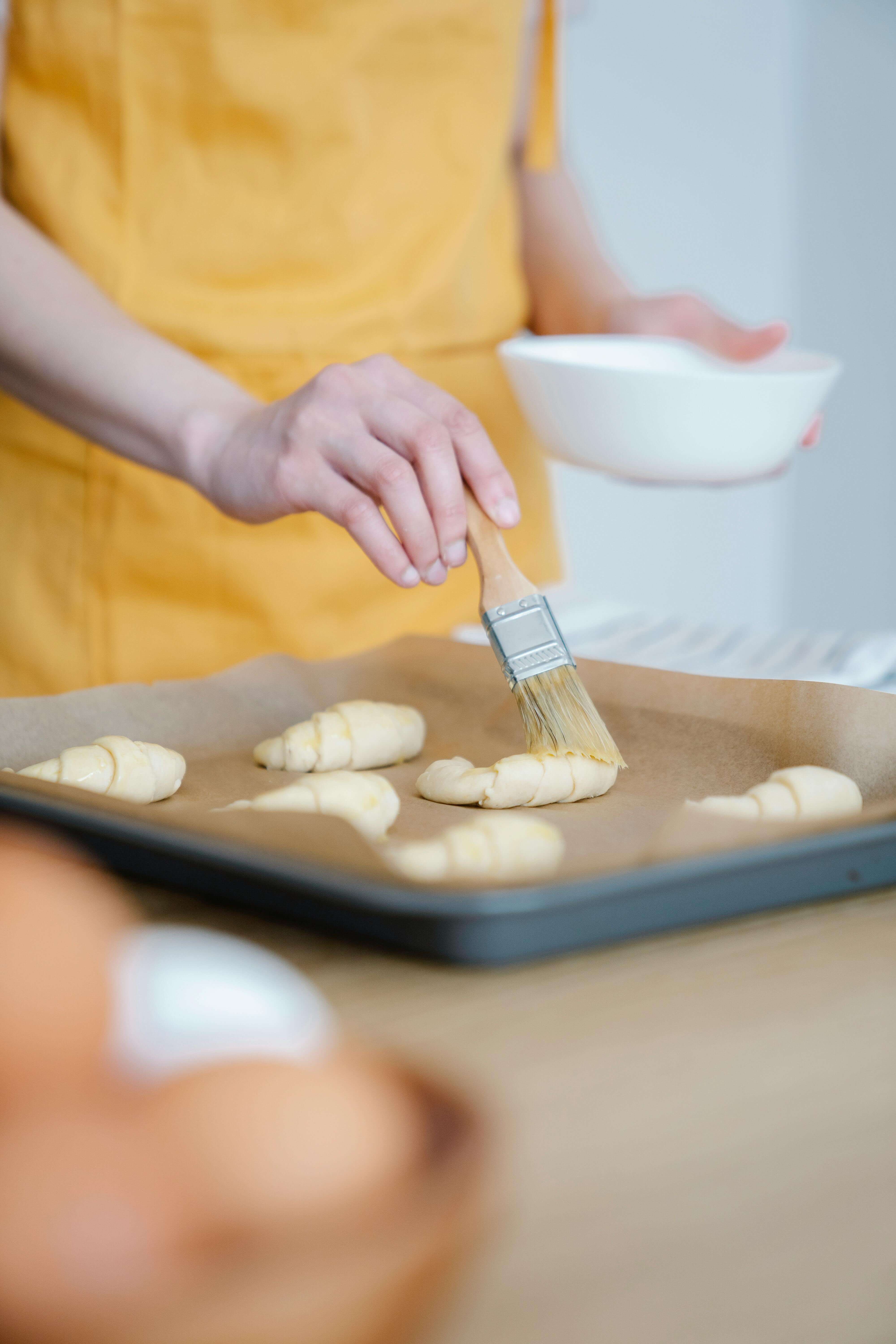 Egg wash being applied to a baked good